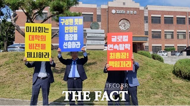 16일 영남대총동창회 비대위가 영남학원 사무실 앞에 피켓을 들고 서 있다./영남대 총동창회 비상대책위원회