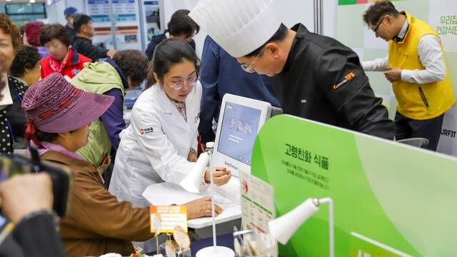 지난 18일 숭실대학교에서 열린 제2회 서울 시니어 스마트 페스타를 방문한 어르신들이 아워홈 부스에서 설명을 듣고 있다. /아워홈