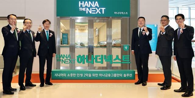 하나금융그룹은 지난 21일 그룹의 시니어 특화 브랜드 하나 더 넥스트(HANA THE NEXT)를 출범하고, 시니어 세대의 성공적인 노후를 위한 특화 서비스를 시행한다고 밝혔다. 이승열 하나은행장(사진 왼쪽에서 세 번째)과 하나 더 넥스트의 광고모델 방송인 강호동(사진 오른쪽에서 세 번째)이 하나은행 임직원과 함께 현판식 진행 후 기념 촬영을 하고 있다. /하나금융그룹