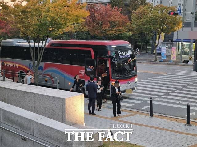 삼성생명 직원들이 추모 음악회에 참석하기 위해 버스에서 내리고 있다. /이성락 기자