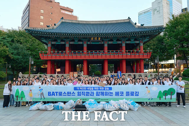 BAT로스만스는 지난 10월 31일 명동 관광특구에서 전직원이 참여하는 환경정화 활동 ‘에코 플로깅’ 캠페인을 진행했다. 이날 행사에 참여한 임직원들이 단체사진을 촬영하고 있다. /BAT로스만스