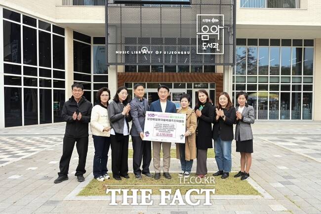 의정부 장암메밀꽃마을축제추진위원회 관계자들이 최근 장암동주민센터에 축제 수익금 379만 5000원 전액을 기부한 뒤 김동근 의정부시장(가운데)과 기념촬영을 하고 있다./의정부시