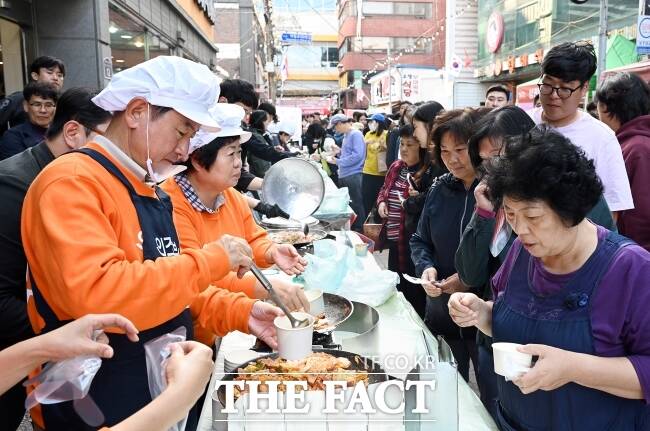 김동근 의정부시장(왼쪽)이 지난 2일 의정부 부대찌개거리에서 열린 ‘제17회 의정부 부대찌개축제’에서 축제를 찾은 시민들에게 음식을 나눠주고 있다./의정부시