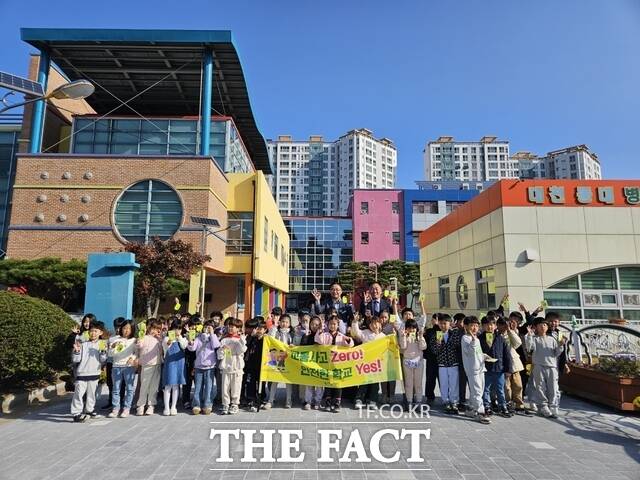 보령시가 지역 내 동대초등학교를 찾아 어린이 교통안전용품인 옐로카드를 홍보·배부하며 기념촬영을 하고 있다. / 보령시