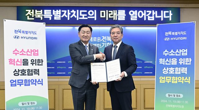 장재훈 현대차 사장(오른쪽)과 김관영 전북자치도지사가 19일 전북 전주시 도청 청사에서 협약서를 들고 기념 촬영을 하고 있다. /현대차