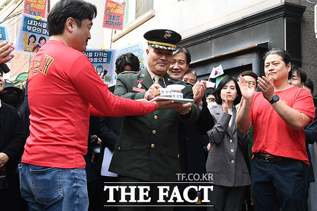 해병대 채 상병 순직사건 수사 이첩 관련 항명 및 상관명예훼손 혐의로 기소된 박정훈 전 해병대 수사단장이 21일 오후 서울 용산구 중앙지역군사법원에서 열린 공판에 출석하기 전 기자회견에서 몰상식, 불공정이라고 적힌 묵사발 케이크를 자르고 있다. /서예원 기자