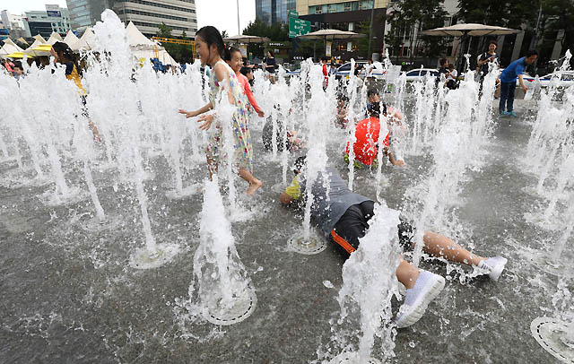 서울과 전국 대부분 지역에 폭염경보가 이어지고 있는 31일 오후 서울 종로구 광화문광장 분수대에서 어린이들이 물놀이를 즐기며 더위를 피하고 있다. /서울=뉴시스