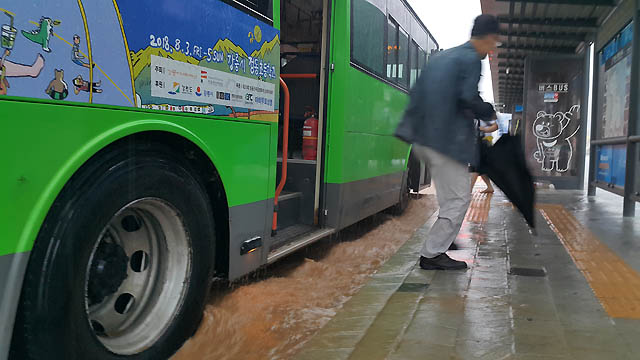 6일 오전 호우경보가 발령된 강원 강릉시에 많은 비가 내려 도심 도로 곳곳이 침수된 가운데 시민이 버스에서 내리고 있다.  /강릉=뉴시스