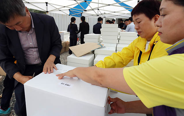 3일 오후 전남 진도군 임회면 팽목항 분향소가 철거되는 가운데 진도군청 직원과 유가족이 단원고 희생자 사진이 담긴 상자를 포장하고 있다./팽목항(진도)=뉴시스  wisdom21@newsis.com