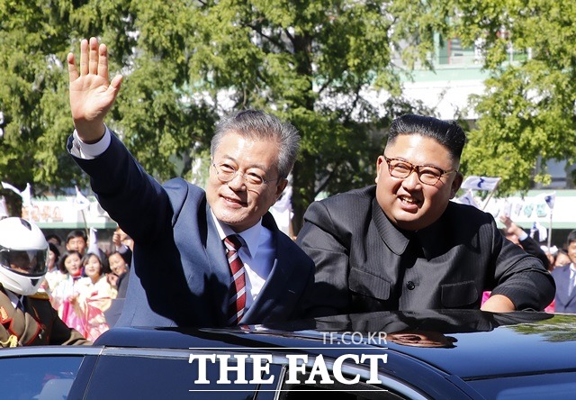 문재인 대통령(왼쪽)과 김정은 국무위원장이 18일 무개차를 타고 평양시내를 퍼레이드 하며 시민들에 환영에 답하고 있다. /평양사진공동취재단
