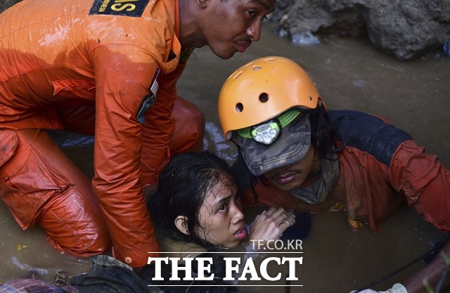 지난달 28일 지진과 쓰나미 피해를 입은 인도네시아 술라웨시섬에서 구조 대원들이 여성을 구조하고 있다. /술라웨시섬(인도네시아)=AP. 뉴시스