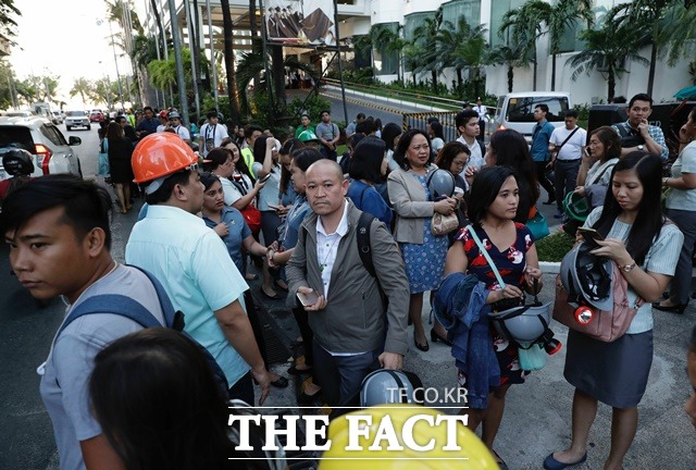 22일(현지시간) 필리핀 마닐라에서 규모 6.1의 지진이 일어나 한 건물의 직원들이 건물 밖으로 대피해 모여 있다. 이 지진으로 최소 5명이 숨지고, 50여 명이 다친 것으로 전해졌다. /AP·뉴시스