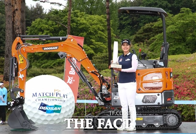 2019 KLPGA 투어 두산 매치플레이 챔피언십에서 우승한 김지현이 트로피를 들고 부상으로 받은 포크레인 앞에서 기념촬영을 하고 있다./춘천=뉴시스