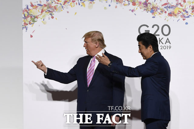 미국 언론 뉴욕타임스가 일본의 한국에 대한 경제 보복조치를 강하게 비판했다. 도널드 트럼프 미국 대통령과 아베 신조 일본 총리가 G20에서 사진촬영을 앞두고 손짓을 하고 있는 모습. /AP.뉴시스