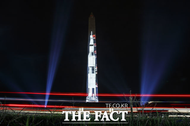 아폴로 11호 발사 50주년을 맞아 16일(현지시간) 미 워싱턴DC의 워싱턴 기념비 앞에 약 110m 높이의 새턴 V 로켓 이미지가 투사되고 있다. /AP.뉴시스