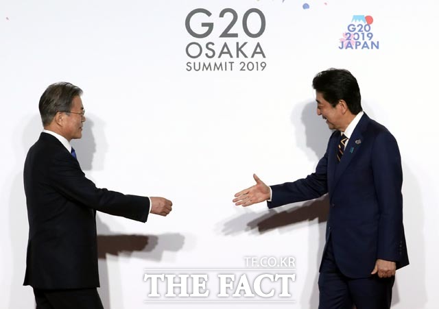 요미우리 신문이 한국 정부가 다음 달 한일정상회담을 추진중이라고 보도했다. 문재인 대통령이 지난 6월 G20 정상회의 공식환영식에서 아베 신조 일본 총리와 악수하고 있다. /뉴시스