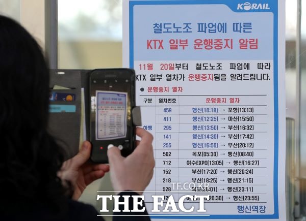 철도노조 파업 사흘째인 22일 오전 경기도 고양시 행신역에서 KTX이용 승객이 운행 중지 열차에 대한 안내문을 핸드폰카메라로 찍고 있다. /뉴시스