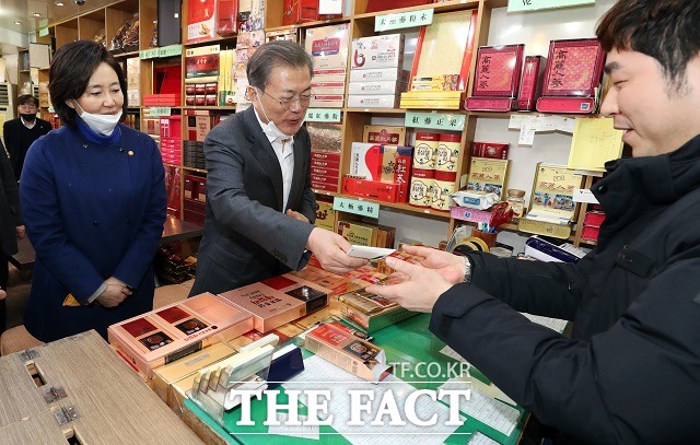 문재인 대통령이 신종 코로나 바이러스 감염증(COVID-19)으로 위축된 내수경제 활성화를 위해 12일 서울 남대문시장을 방문해 홍삼 액기스를 구입하고 있다. /뉴시스