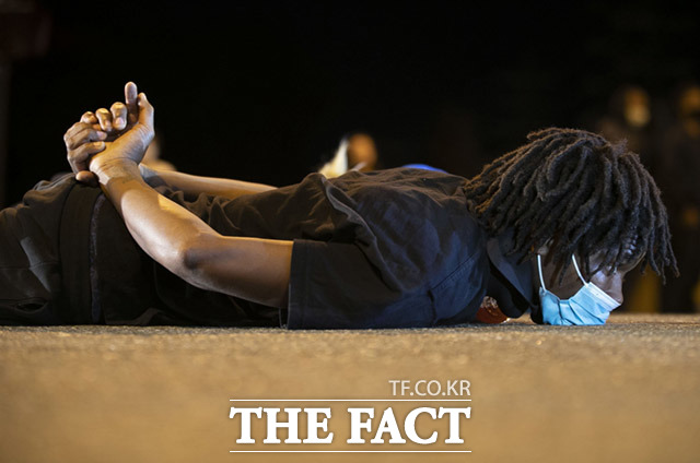 조지 플로이드의 사망으로 인종차별 반대 시위는 미국 전역으로 확대됐다. 사진은 지난 1일 미국 노스캐롤라이나주 더럼에서 시위가 진행중인 가운데 한 남성이 플로이드 사망 당시 모습으로 도로에 엎드려 추모와 항의를 표현하는 모습. /노스캐롤라이나=AP.뉴시스