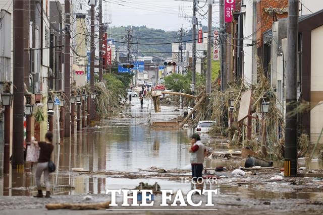 지난 4일 일본 규슈지역 구마모토(熊本)현 히토요시(人吉)시에서 폭우로 가옥이 물에 잠기자 주민들이 지붕 위에 올라가 구조를 기다리고 있는 모습. /(일본 구마모토현)=AP·뉴시스