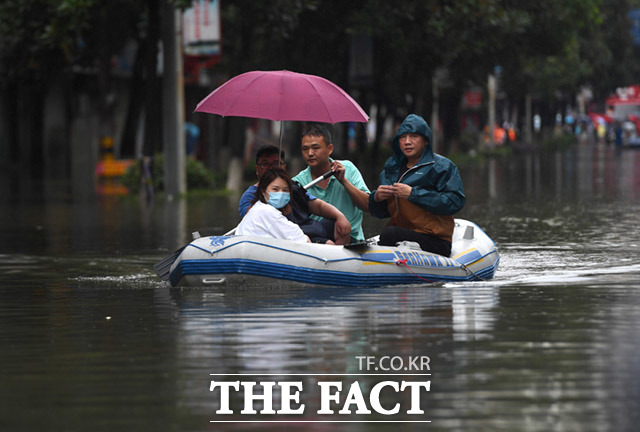 중국 남부지역에 한 달째 폭우경보가 이어지고 있는 가운데 8일 중국 동부 장시성 징더전에서 구조 대원들이 고무보트로 홍수에 갇힌 주민들을 구조하고 있다. /징더전=신화통신.뉴시스