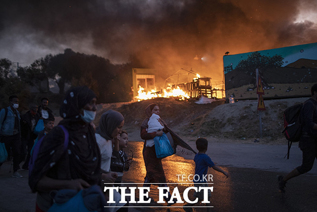 9일(현지시간) 그리스 레스보스섬의 모리아 난민수용소에서 두 번째 화재가 발생해 수용 중이던 난민들이 대피하고 있다. / 레스보스=AP.뉴시스