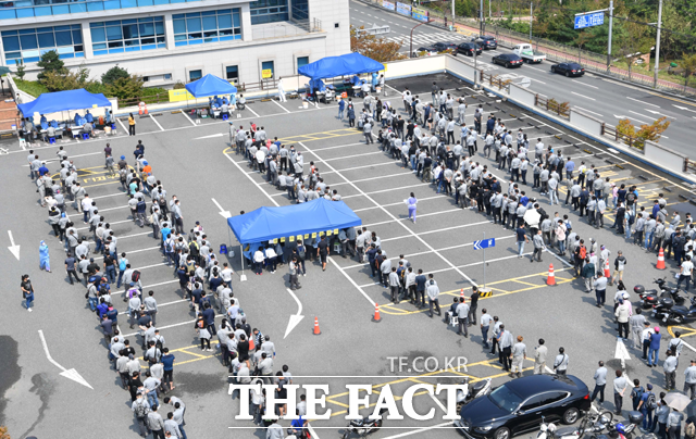 9일 오후 울산 동구보건소 선별진료소에 현대중공업 직원들이 검사를 받기 위해 줄지어 서 있다. /뉴시스