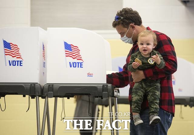 미국은 전체 득표수와 상관없이 각주마다 할당된 선거인단 총 535명 중 과반 이상(270)을 차지하면 승부가 난다. 미 대선 투표일인 3일(현지시간) 미 버지니아주 버지니아 비치의 앨런턴 초등학교 투표소에서 한 남성이 아들과 함께 투표하고 있다. /AP.뉴스