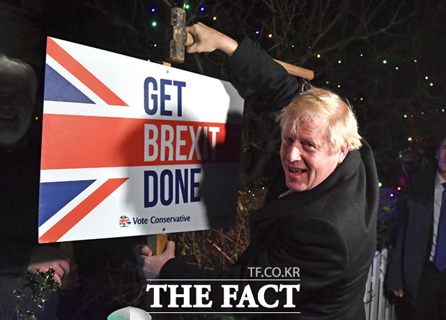 보리스 존슨 총리가 지난 2019년 12월 영국 벤플리트에 위치한 지지자의 집 정원에서 Get Brexit Done문구가 적힌 피켓을 두드리며 포즈를 취하고 있습니다.