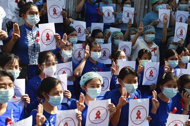 5일 미얀마 양곤의 양곤 교육대 캠퍼스 앞에 교사들이 모여 미얀마 교사들, 시민 불복종이라고 쓰인 팻말을 들고 세 손가락을 들어 저항의 표시를 하고 있다. 이들은 붉은리본을 달고 학교 앞에 모여 쿠데타 반대 시위를 벌였다. /양곤=AP/뉴시스