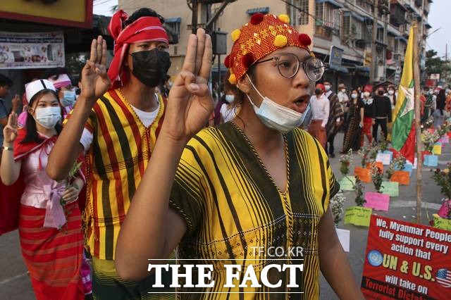 25일 미얀마 양곤에서 쿠데타 반대 시위대가 세 손가락 경례를 하며 구호를 외치고 있다. 미얀마 시위대는 24일 집 안에 머물며 상점 문을 닫는 등 침묵시위를 벌인 지 하루 만에 다시 거리로 나왔다./양곤=AP/뉴시스