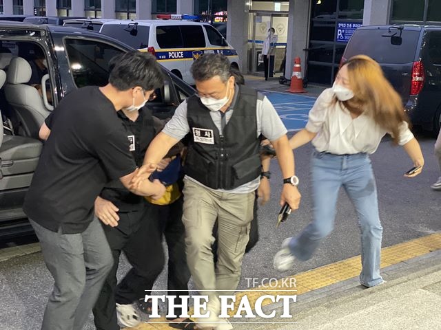 서울 마포구에서 지인을 살해하고 도주한 혐의로 경상북도 경산시에서 검거된 40대 A씨가 15일 오후 7시50분께 점퍼로 얼굴을 가리고 경찰관들에 둘러싸여 마포경찰서로 들어가고 있다. /뉴시