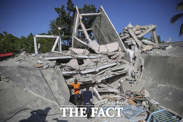 아이티 국민들이 14일(현지시간) 아이티에서 발생한 규모 7.2의 지진으로 무너진 집 잔해 속에서 생존자를 찾고 있다. /레카이=AP.뉴시스