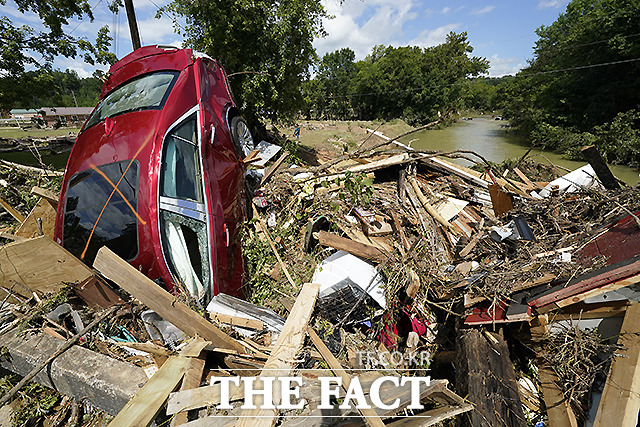 테네시주 웨이벌리에서 자동차 한 대가 개울 위의 파손된 다리의 잔해들 사이에 처 박혀 있다. /테네시=AP.뉴시스