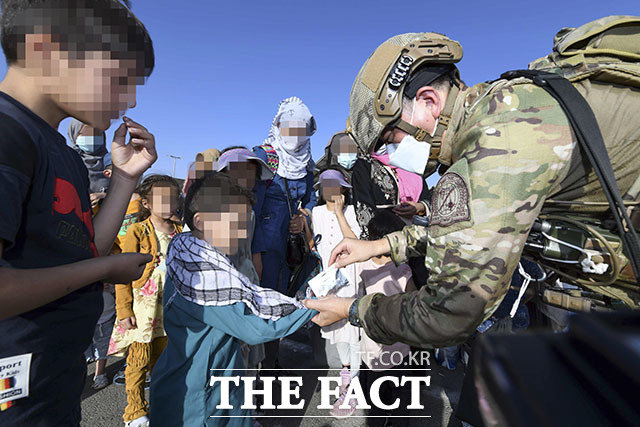 공군 최정예 특수부대 요원인 공정통제사(CCT : Combat Control Team)가 25일(현지시간) 아프가니스탄 카불공항에서 한국으로 이송될 아프간인 현지 조력자의 자녀들에게 간식을 제공하고 있다. /뉴시스