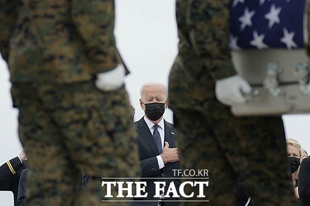 조 바이든 미국 대통령이 29일(현지시간) 미국 델라웨어주 도버 공군기지에서 카불 공항 자살폭탄 테러로 희생된 미군 유해 13구가 운구되는 것을 지켜보며 침통한 표정을 짓고 있다. /도버 공군기지=AP.뉴시스