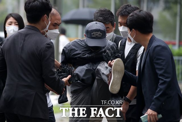 위치추적 전자장치(전자발찌)를 끊기 전후로 여성 2명을 살해한 것으로 조사된 50대 성범죄 전과자 강 모씨가 31일 오전 서울 송파구 서울동부지법에서 열린 영장실질심사(구속 전 피의자 심문)에 출석하며 취재진 마이크를 발로 걷어차고 있다. /뉴시스