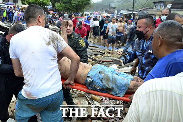 8일(현지시간) 콜롬비아 페레이라에 산사태가 발생해 구조대가 생존자를 구조해 옮기고 있다. 현지 당국은 페레이라와 도스케브라다스에 내린 폭우로 무너진 토사가 주택가를 강타해 최소 14명이 숨지고 35명이 다쳤다고 밝혔다. /페레이라(콜롬비아)=AP.뉴시스