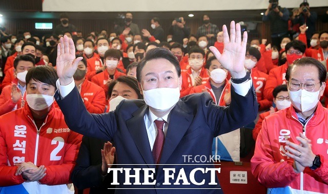 윤석열 제20대 대통령 당선인이 10일 새벽 서울 여의도 국회도서관에 마련된 국민의힘 제20대 대통령선거 개표상황실에서 꽃다발을 받은 뒤 포즈를 취하고 있다. /뉴시스