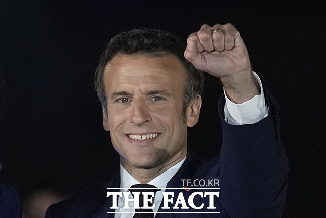 연임에 성공한 에마뉘엘 마크롱 프랑스 대통령이 24일(현지시간) 대선 결선 투표에서 승리한 후 파리의 샹드마르스 광장을 찾아 지지자들을 향해 주먹을 들어 인사하고 있다./파리=AP.뉴시스