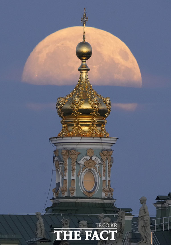러시아 상트페테르부르크의 교휘 위로 구름을 뚫고 커다란 보름달이 뜨고 있다.