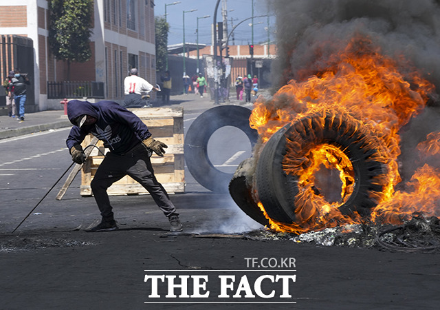 16일(현지시간) 에콰도르 키토에서 원주민 단체가 이끄는 기예르모 라소 정권 반대 시위가 이어진 가운데 한 시위 참가자가 타이어를 태우고 있다. /키토=AP.뉴시스