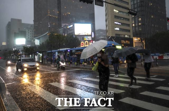 서울시가 호우경보에 대비해 비상수송대책을 시행한다. 23일 오후 서울 종로구 광화문광장 인근에서 시민들이 우산을 쓴 채 이동하고 있다. /뉴시스