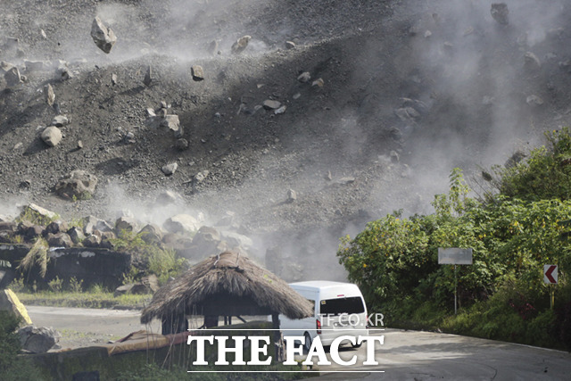 필리핀 수도 마닐라에서 북쪽으로 300㎞ 넘게 떨어진 루손섬 아브라주에서 27일(현지시간) 규모 7.1의 강진이 발생한 가운데 차량이 지나가는 도로 위로 바위들이 쏟아져 내리고 있다. /아브라주=AP.뉴시스
