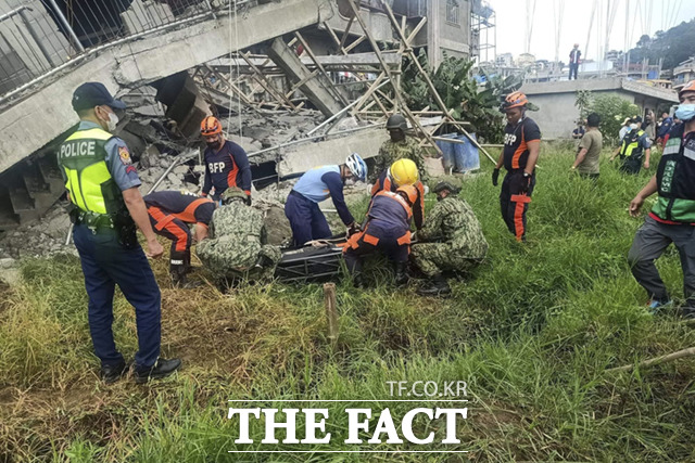 소방국이 제공한 이 사진에서 구조대원들이 지난 27일(현지시간) 필리핀 북부 벵게트주 라 트리니다드에서 강진이 발생한 후 무너진 구조물 밑에서 주민을 구조하고 있다. /벵게트주=AP.뉴시스