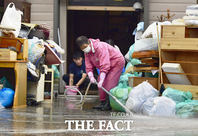 이상기후로 인해 세계 곳곳에서 폭염과 폭우가 이어지고 있는 가운데 10일 일본 아오모리현 아지가사와 마을 주민들이 침수됐던 가구 및 생활 집기들을 세척하고 있다. /아지가사와=AP.뉴시스