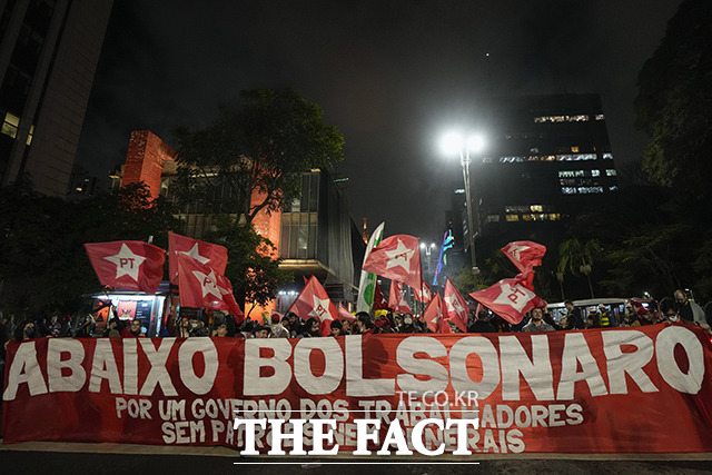 민주주의 수호 시위대가 보우소나루를 타도하라라고 적힌 현수막을 들고 행진하고 있다. 이들은 오는 10월에 열리는 브라질 대선에서 보우소나루 현 대통령의 연임을 반대하며 목소리를 높혔다. /상파울루=AP.뉴시스