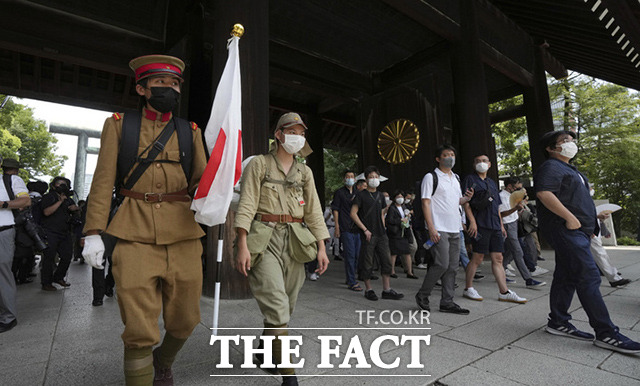 일본의 패전 기념일인 15일 도쿄의 야스쿠니 신사를 찾은 극우 세력 관람객들이 제국주의 시절의 육군 군복을 입고 일장기를 들고 경내로 입장하고 있다. /도쿄=AP.뉴시스