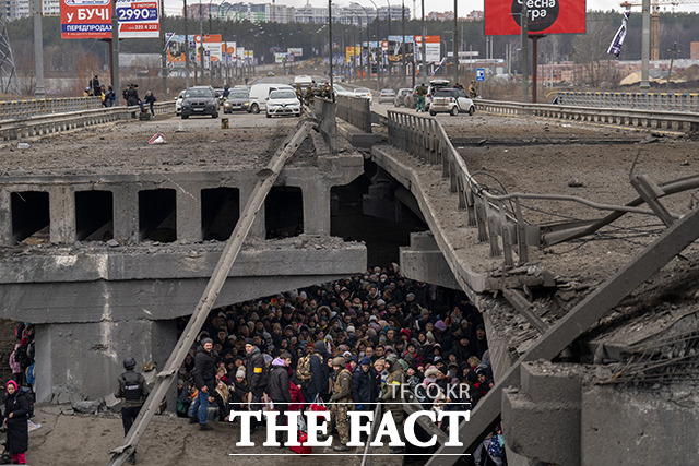 5월 5일, 우크라이나 사람들이키이우 외곽의 이르핀 강을 건너 피란가려고 파괴된 다리 아래에 모여 있다. /키이우=AP.뉴시스