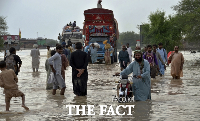 22일(현지시간) 파키스탄 남서부 발루치스탄의 나시라바드에서 주민들이 폭우로 인해 물에 잠긴 도로를 걷고 있다. /나시라바드=AP.뉴시스
